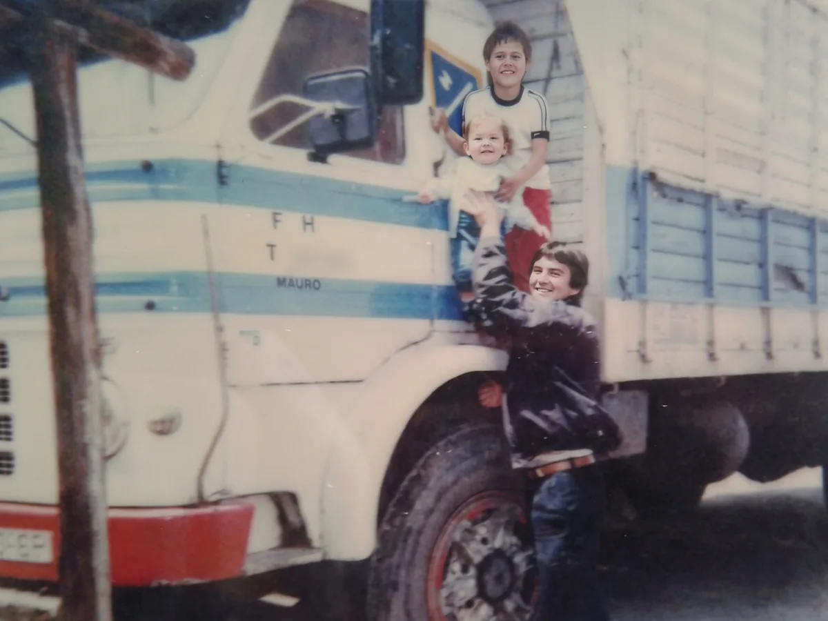 Nuestra historia: un joven y dos niños posan junto a un antiguo camión de la empresa con las letras FHT